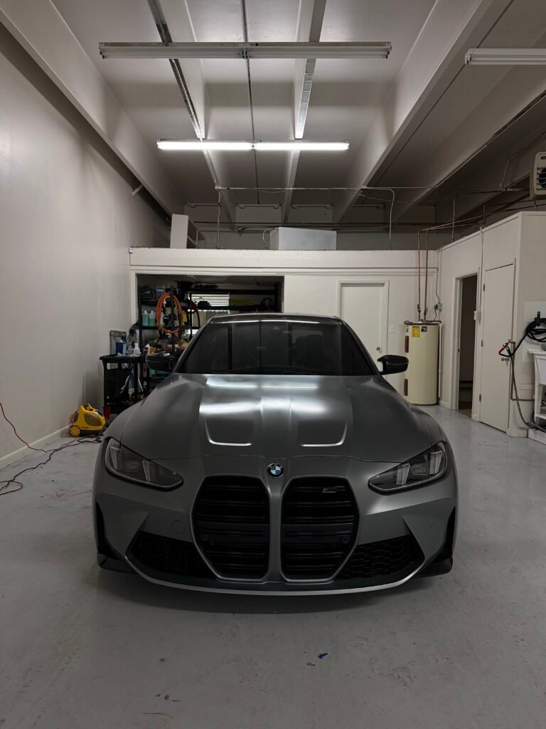 Matte gray BMW M4 parked inside professional auto detailing studio in Littleton Colorado