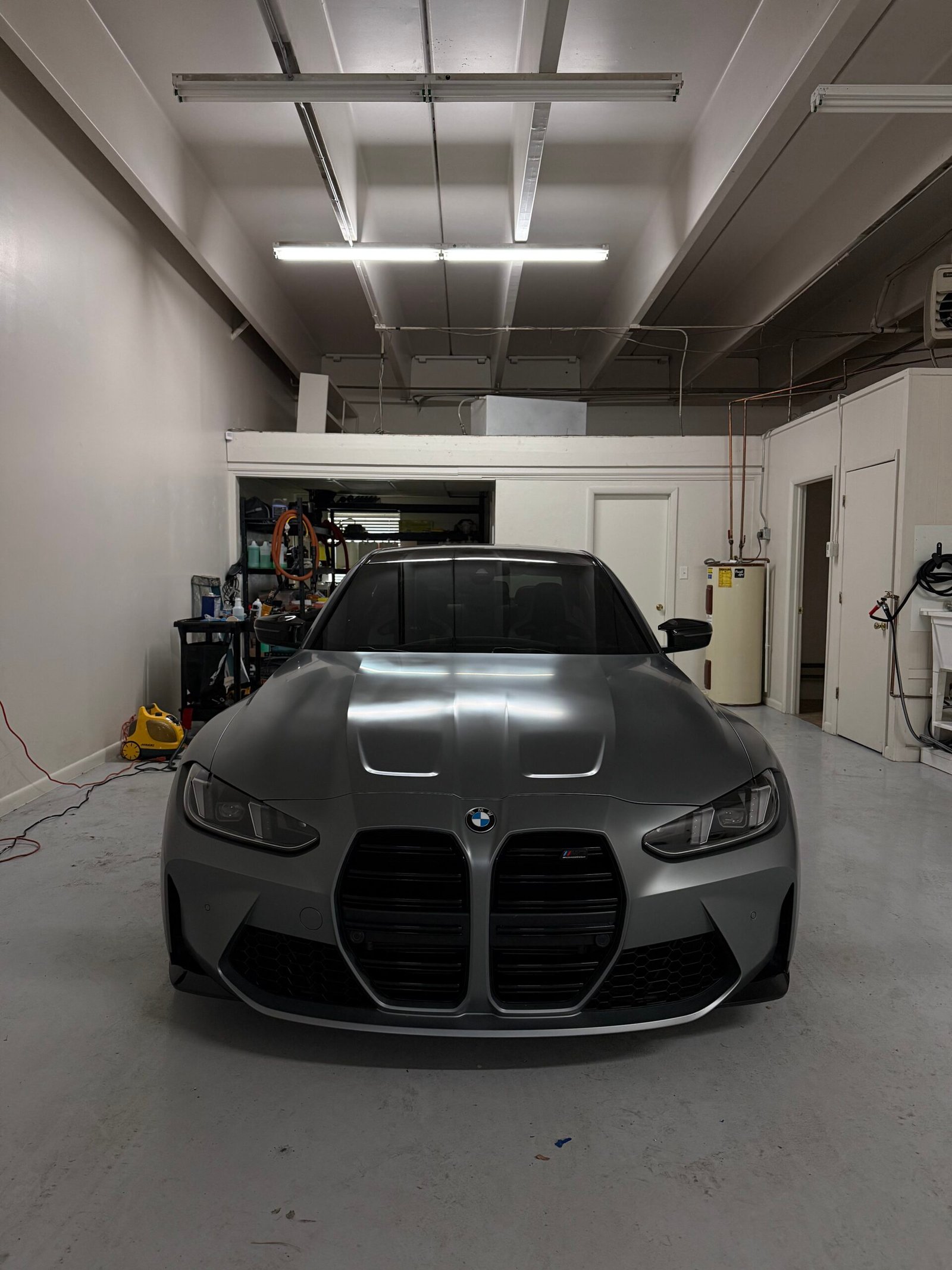 Matte gray BMW M4 parked inside professional auto detailing studio in Littleton Colorado